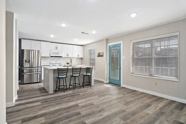 a kitchen with a refrigerator and a table chair