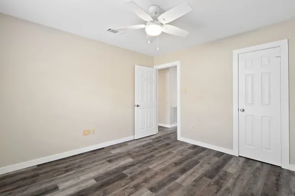 a view of an empty room with wooden floor