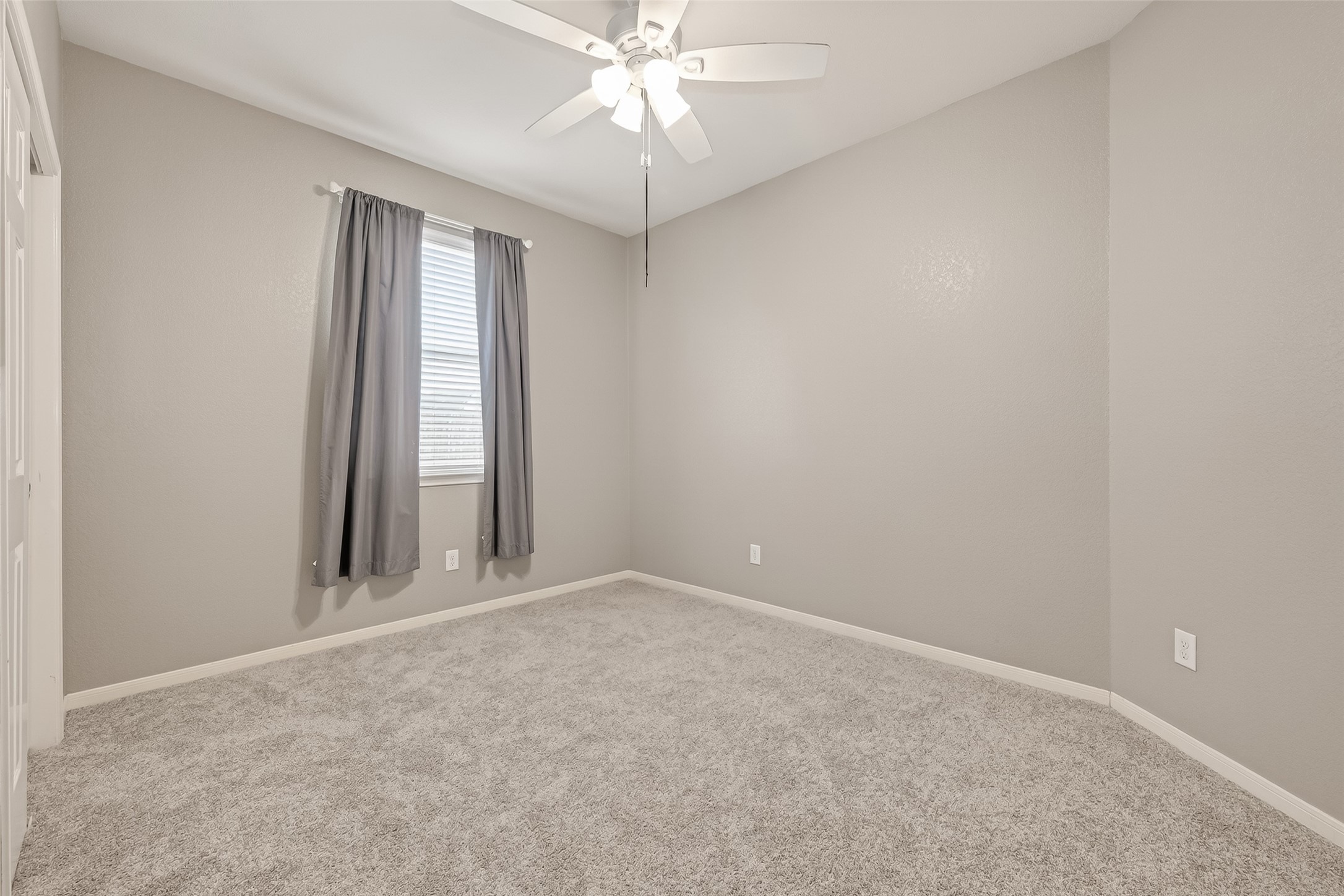 9110 Cavalier Lane Rosenberg, TX 77469 - Photo 17 of 30 an empty room with chandelier fan and windows