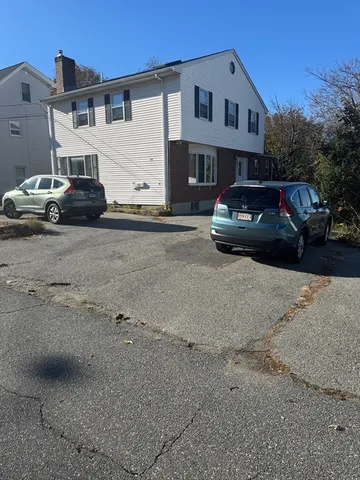 a car parked in front of a white house