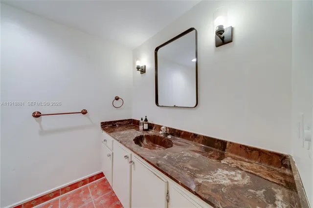 a bathroom with a granite countertop sink and a mirror