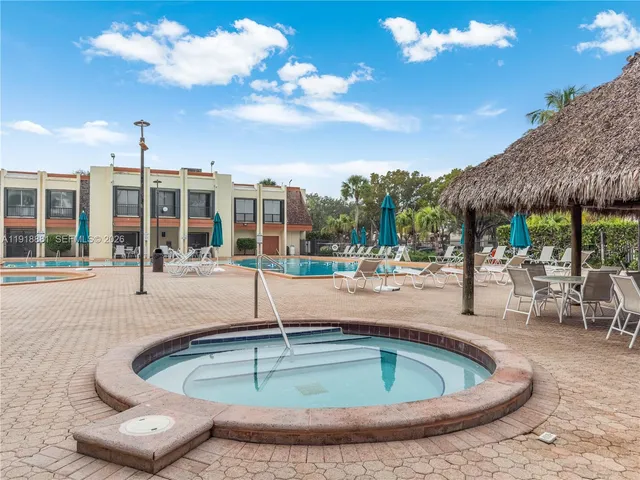 a view of a swimming pool with a patio and dining space