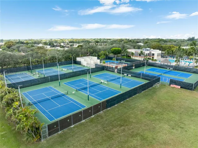 a view of a tennis ground with large trees