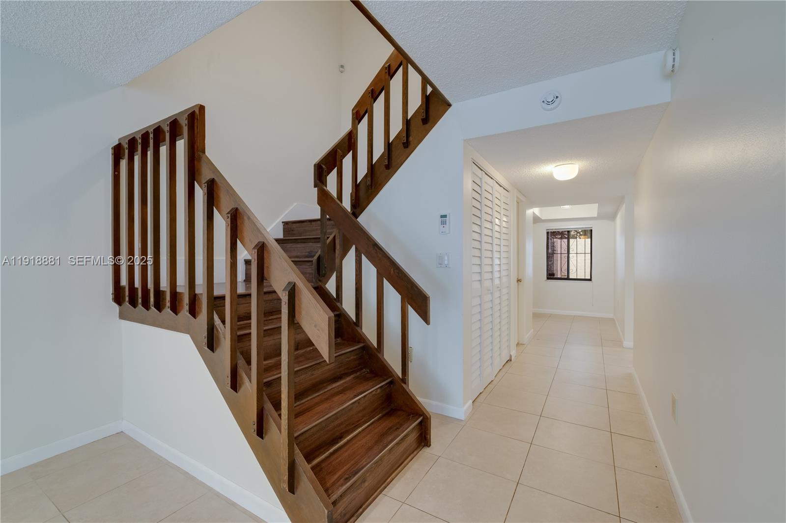 7827 Southwest 106th Circle, Unit 7827 Miami, FL 33173 - Photo 6 of 23 a view of staircase with lots of frames and frames on wall