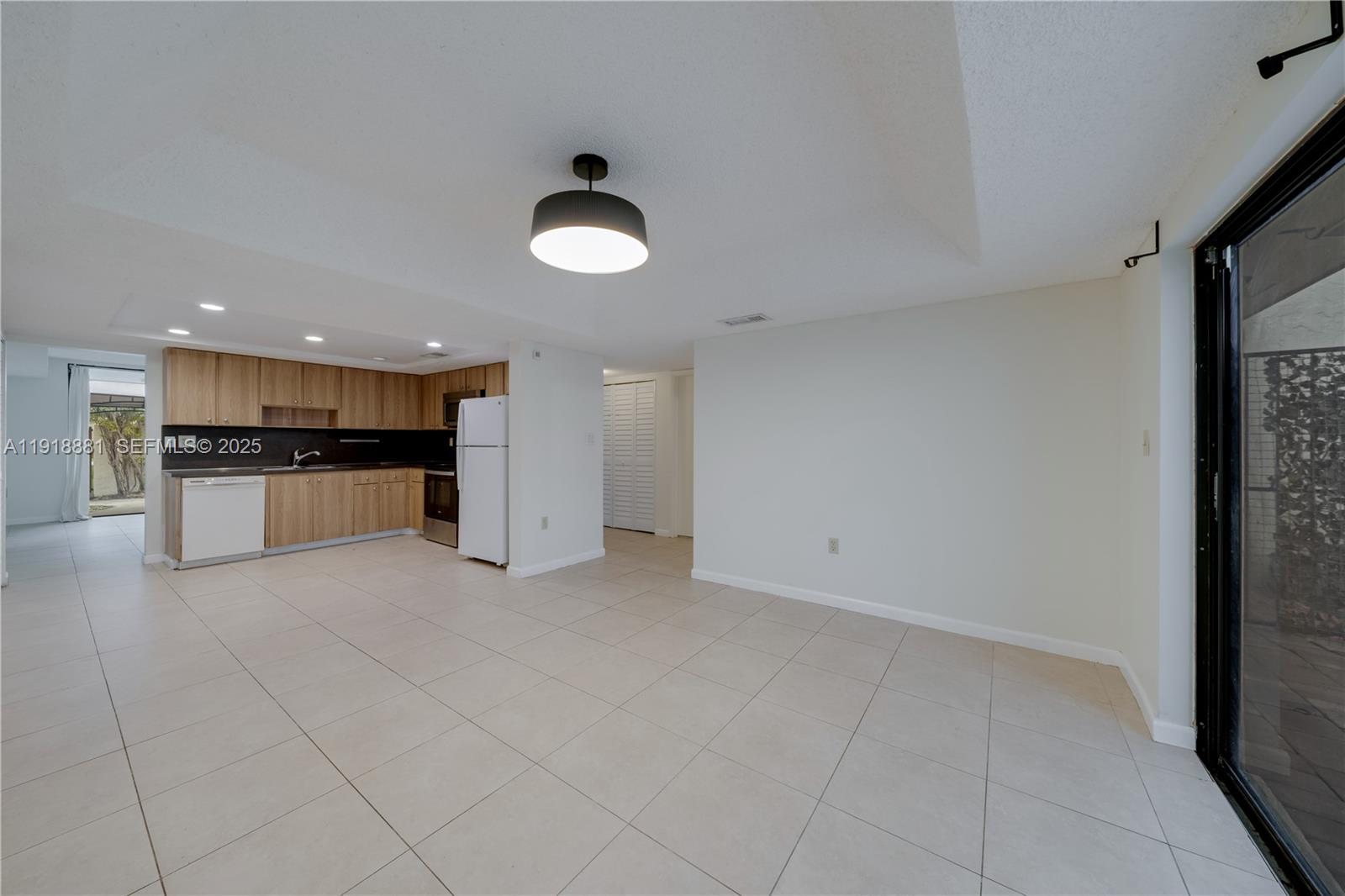 7827 Southwest 106th Circle, Unit 7827 Miami, FL 33173 - Photo 9 of 23 a view of a electric appliances in kitchen and empty room with wooden floor