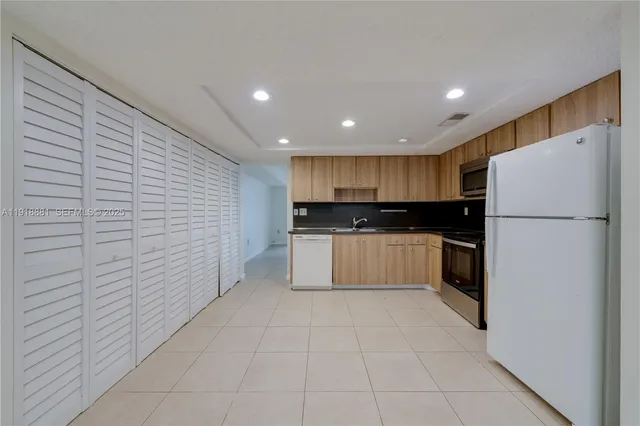a kitchen with a refrigerator and a sink