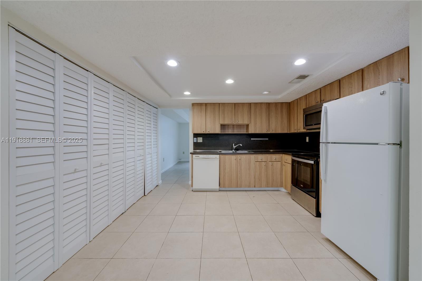 7827 Southwest 106th Circle, Unit 7827 Miami, FL 33173 - Photo 10 of 23 a kitchen with a refrigerator and a sink