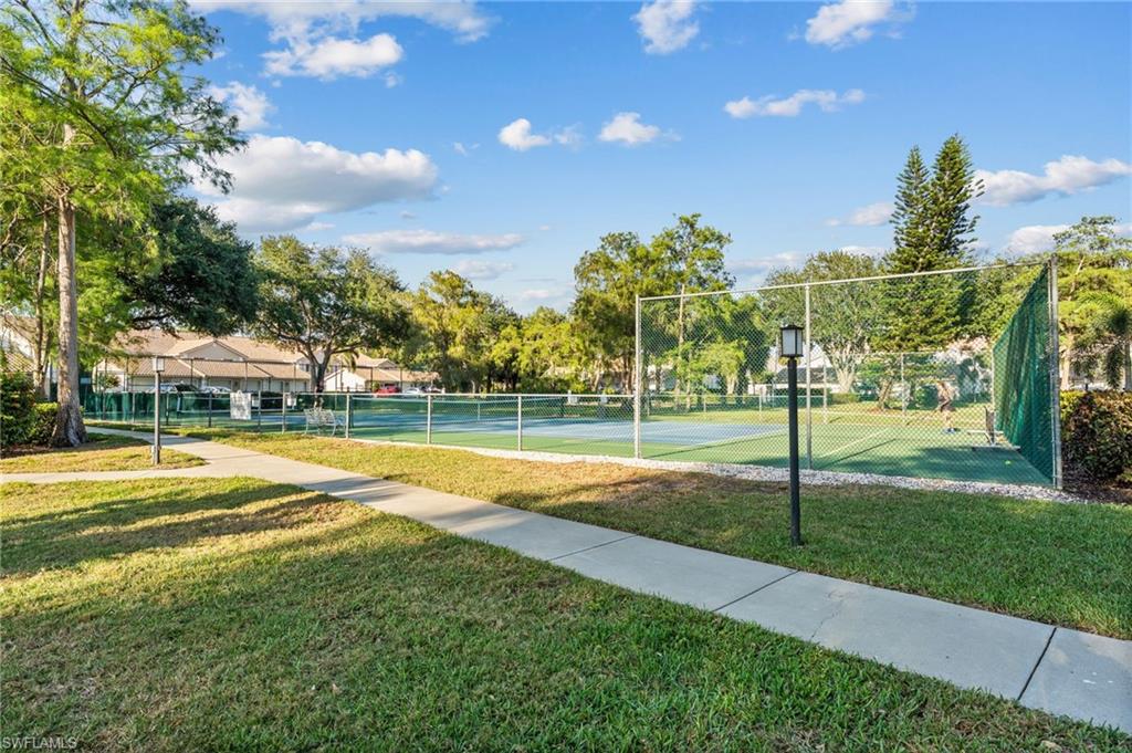 5928 Cranbrook Way, Unit D202 Naples, FL 34112 - Photo 19 of 23 Surrounding community featuring fence, a lawn, and a tennis court