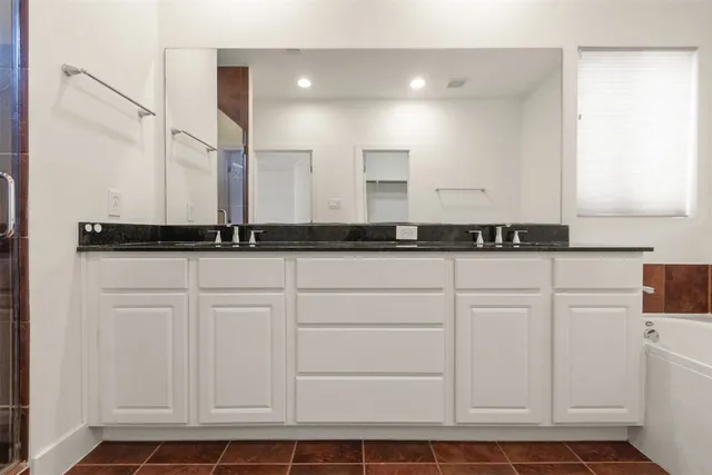 a large bathroom with a granite countertop sink and a mirror