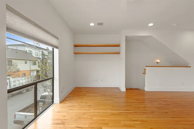 a view of a hallway with wooden floor and entryway