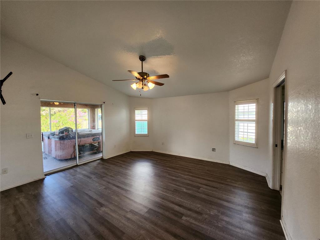 23104 Rountree Avenue Port Charlotte, FL 33980 - Photo 17 of 41 a view of an empty room with wooden floor and a window