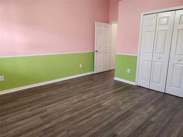a view of a room with wooden floor and white walls