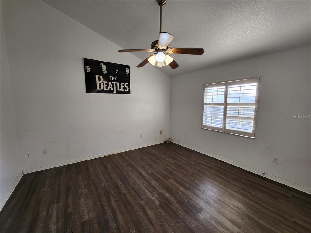 23104 Rountree Avenue Port Charlotte, FL 33980 - Photo 31 of 41 an empty room with wooden floor ceiling fan and windows