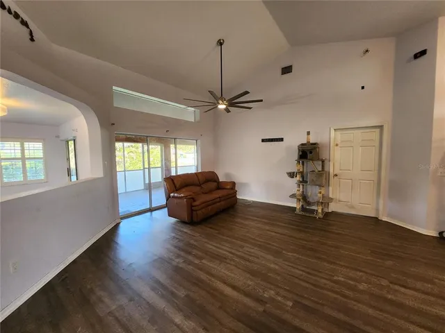 a view of a livingroom with wooden floor and a ceiling fan