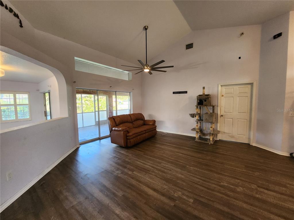 23104 Rountree Avenue Port Charlotte, FL 33980 - Photo 7 of 41 a view of a livingroom with wooden floor and a ceiling fan