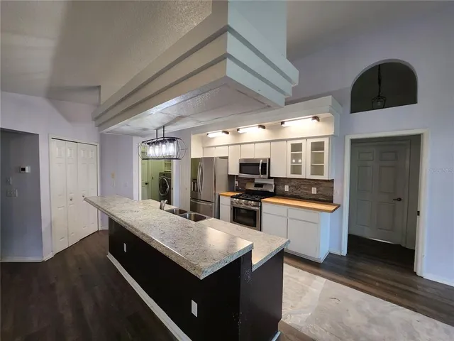 a kitchen with granite countertop cabinets a sink a window and stainless steel appliances
