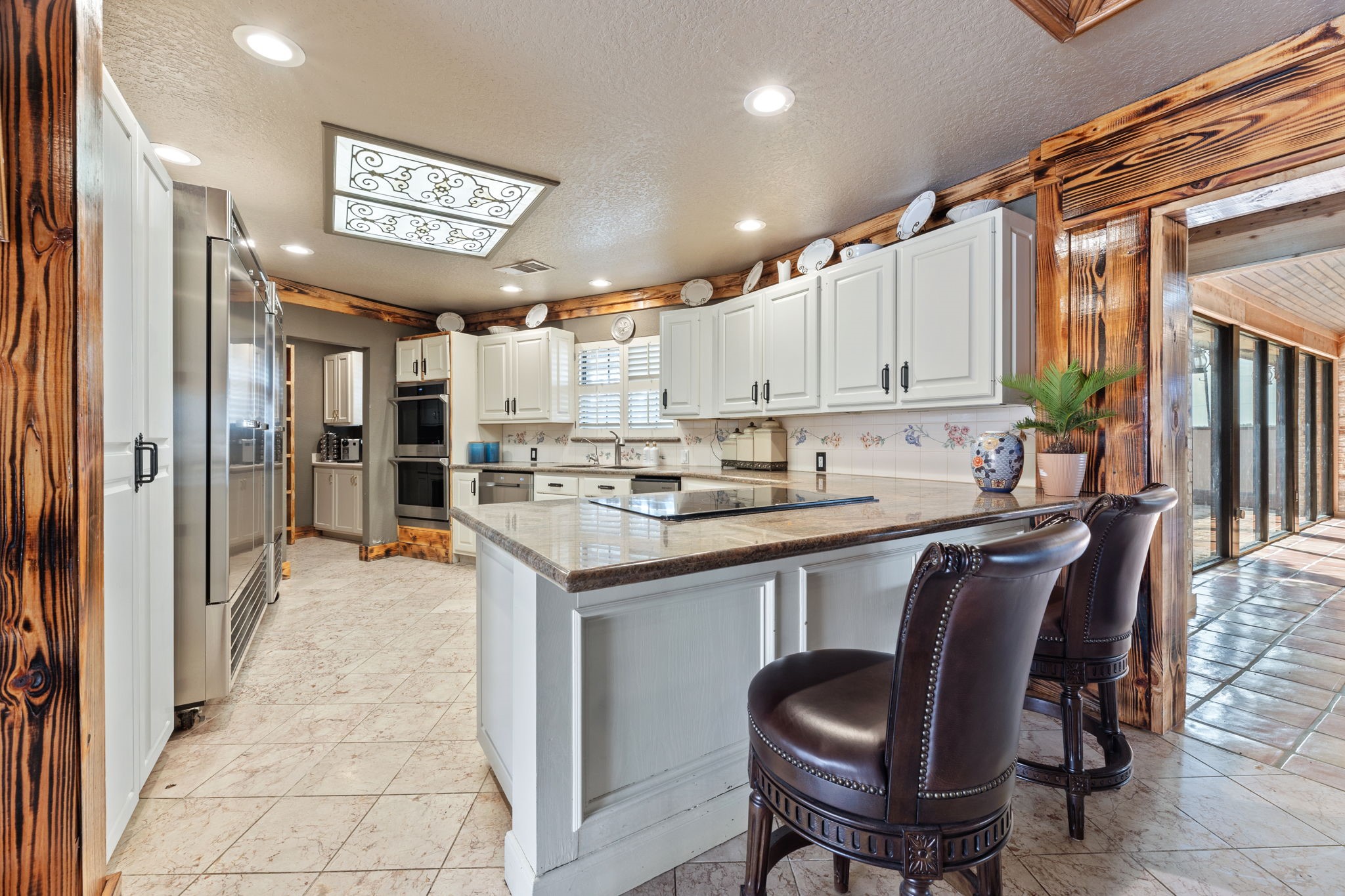 1226 County Road 45 Angleton, TX 77515 - Photo 28 of 44 a kitchen with stainless steel appliances granite countertop a table chairs cabinets and wooden floor