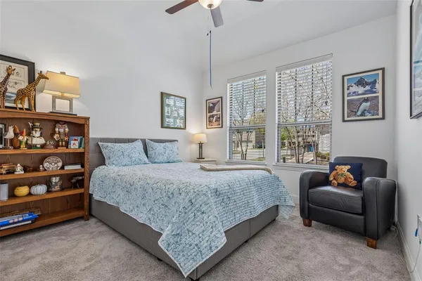 a spacious bedroom with a bed a couch and a chandelier