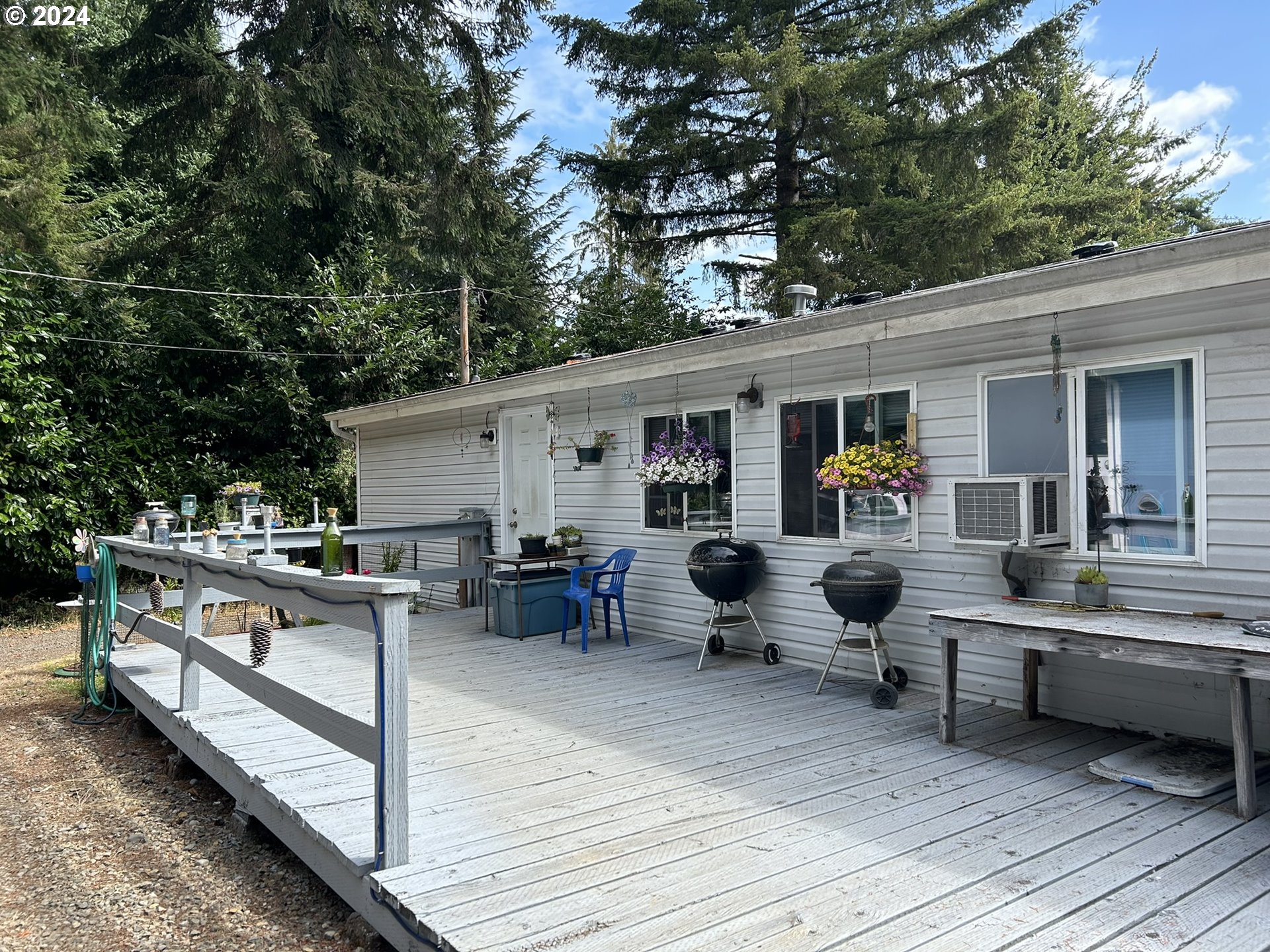 5391 Buckskin Bob Road Florence, OR 97439 - Photo 22 of 42 a view of a patio with dining table and chairs with wooden floor and fence
