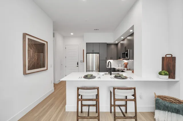 a picture of a room with a white wall and a refrigerator