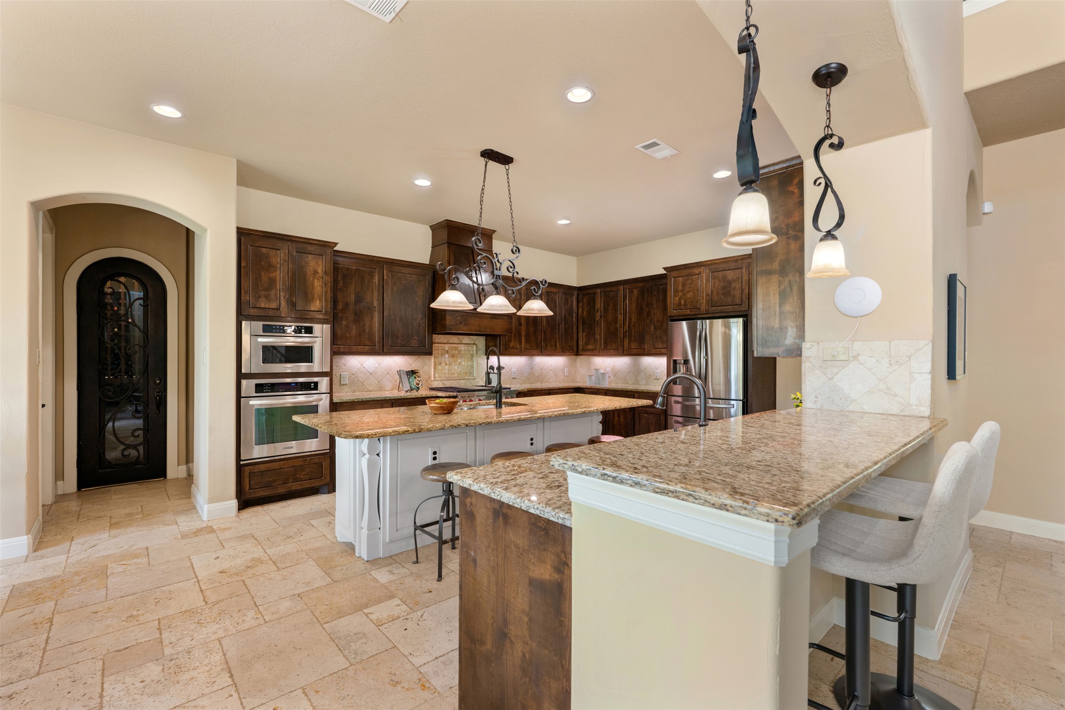 1102 Paw Print Leander, TX 78641 - Photo 12 of 40 Kitchen featuring light-colored tiled flooring, dark wood cabinetry, granite countertops, and stainless steel appliances