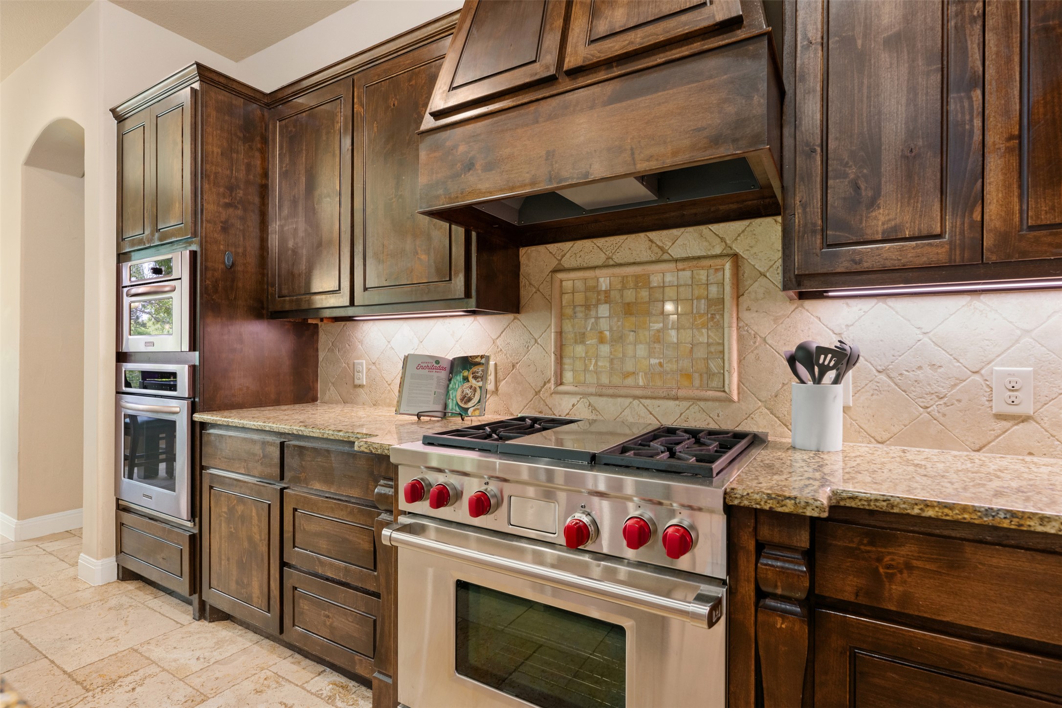 1102 Paw Print Leander, TX 78641 - Photo 14 of 40 The kitchen features rich wood cabinetry, granite countertops, and a tiled backsplash