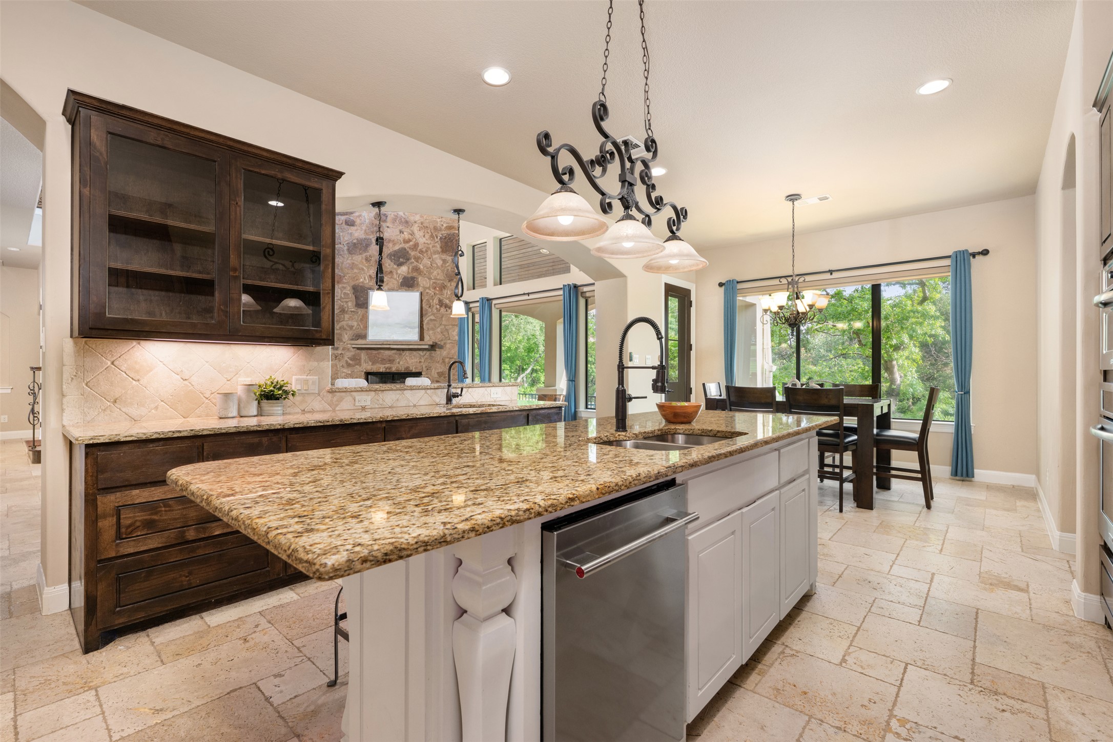 1102 Paw Print Leander, TX 78641 - Photo 15 of 40 The kitchen features granite countertops, dark wood cabinetry, and a central island with an integrated dishwasher