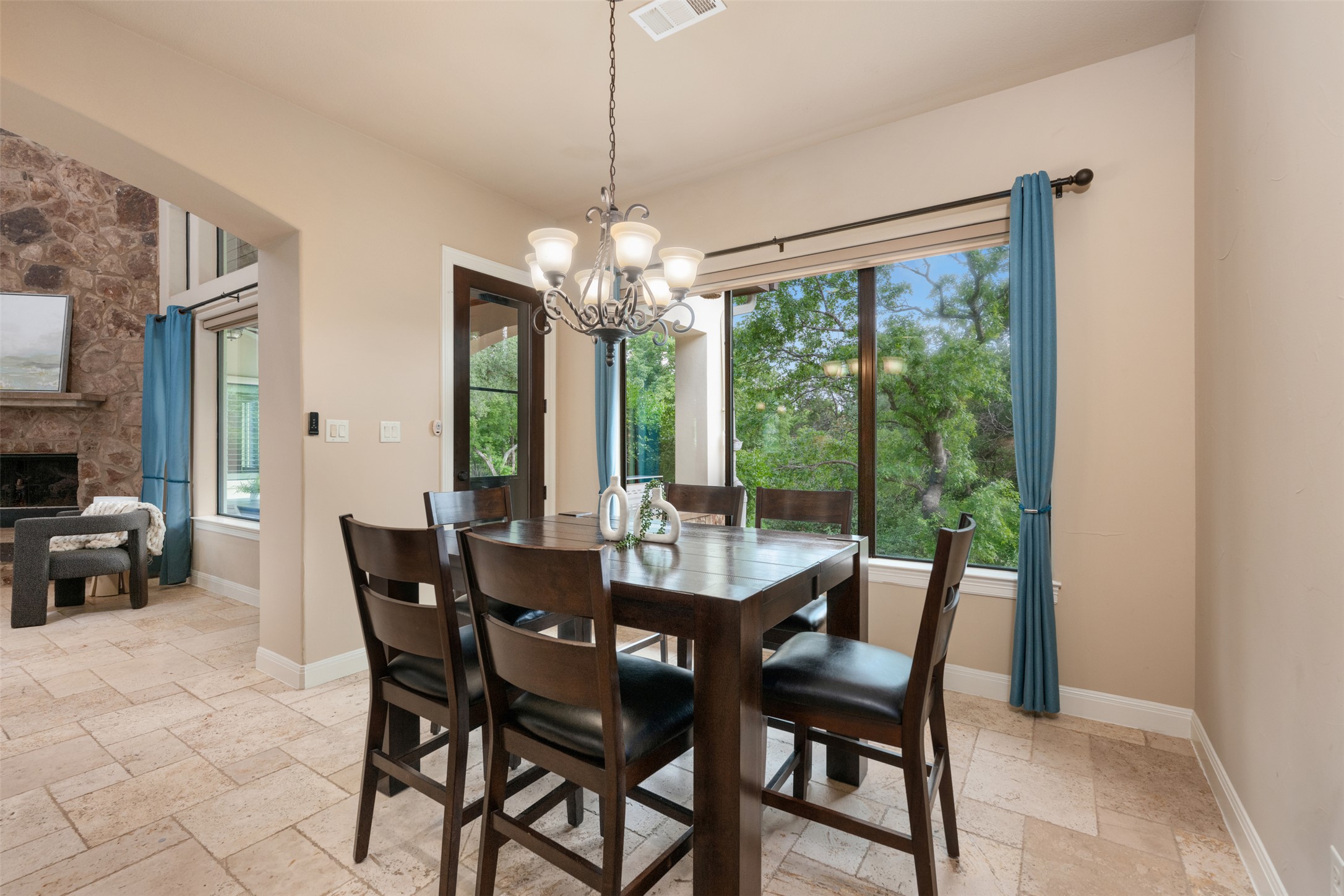 1102 Paw Print Leander, TX 78641 - Photo 17 of 40 The dining area features tiled flooring, a window offering views of lush greenery, and a chandelier providing overhead lighting