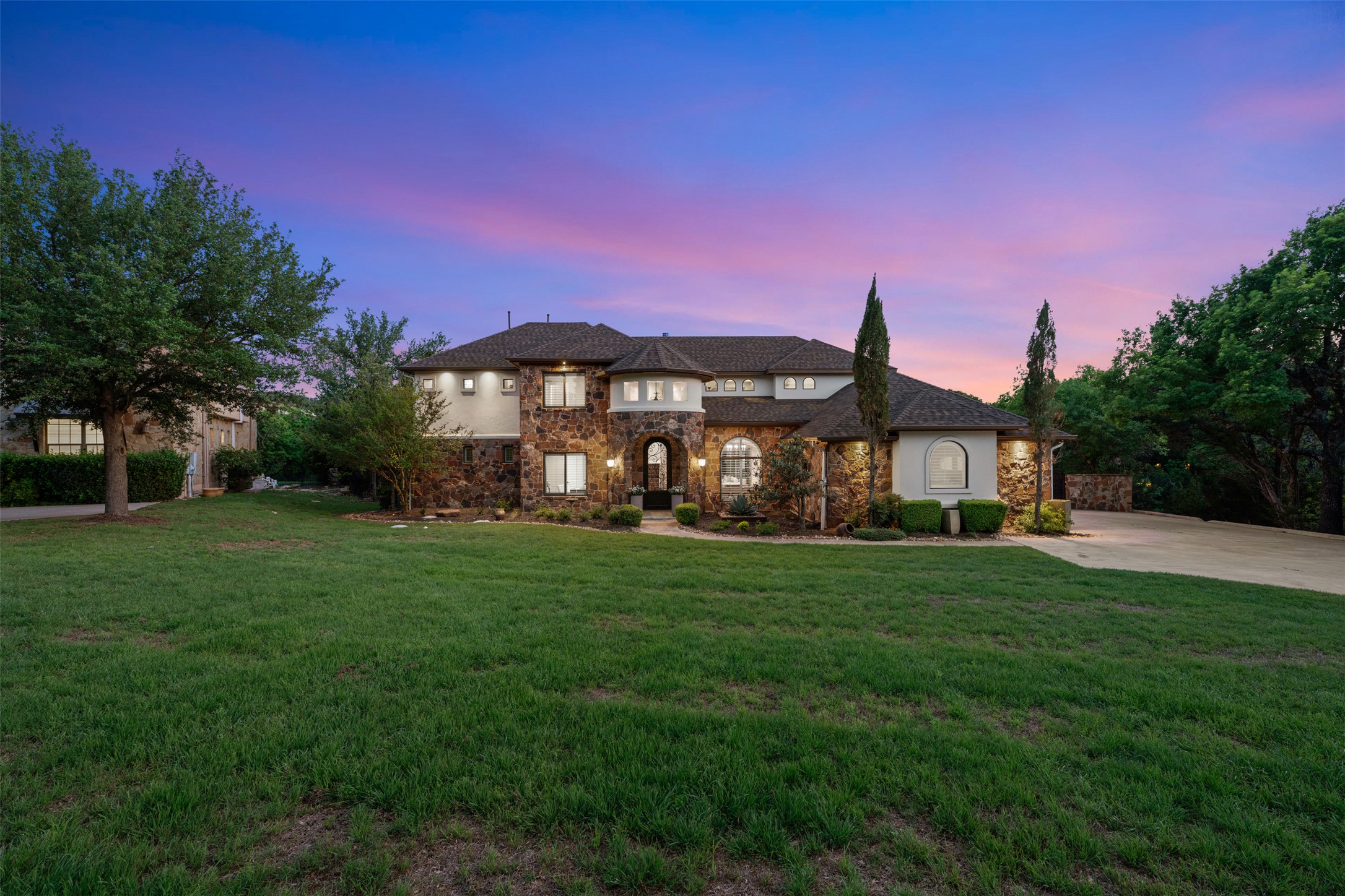 1102 Paw Print Leander, TX 78641 - Photo 36 of 40 The property features a stone and stucco exterior, arched windows, and a well-maintained lawn