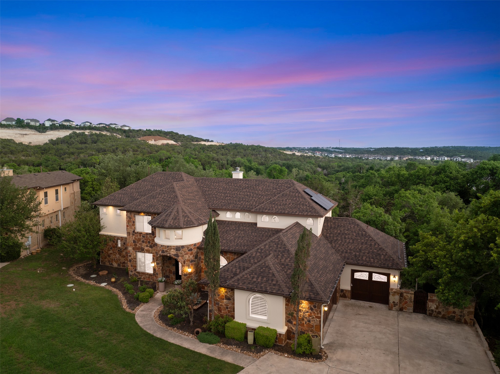 1102 Paw Print Leander, TX 78641 - Photo 37 of 40 This property features a stone and stucco exterior, a multi-car garage, and a lush green lawn