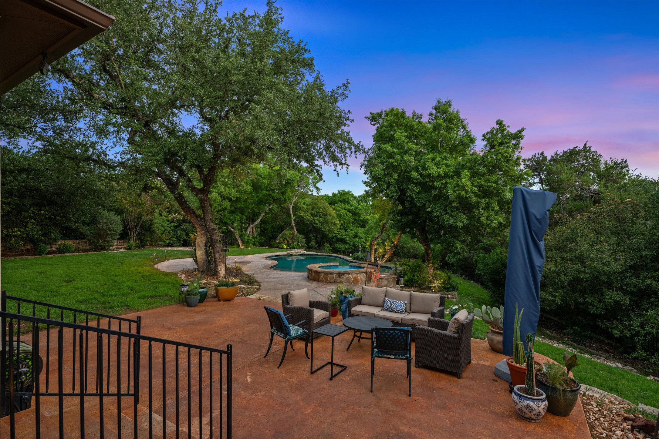 1102 Paw Print Leander, TX 78641 - Photo 38 of 40 The expansive outdoor space features a paved patio, a swimming pool with an integrated spa, and a well-maintained lawn with mature trees