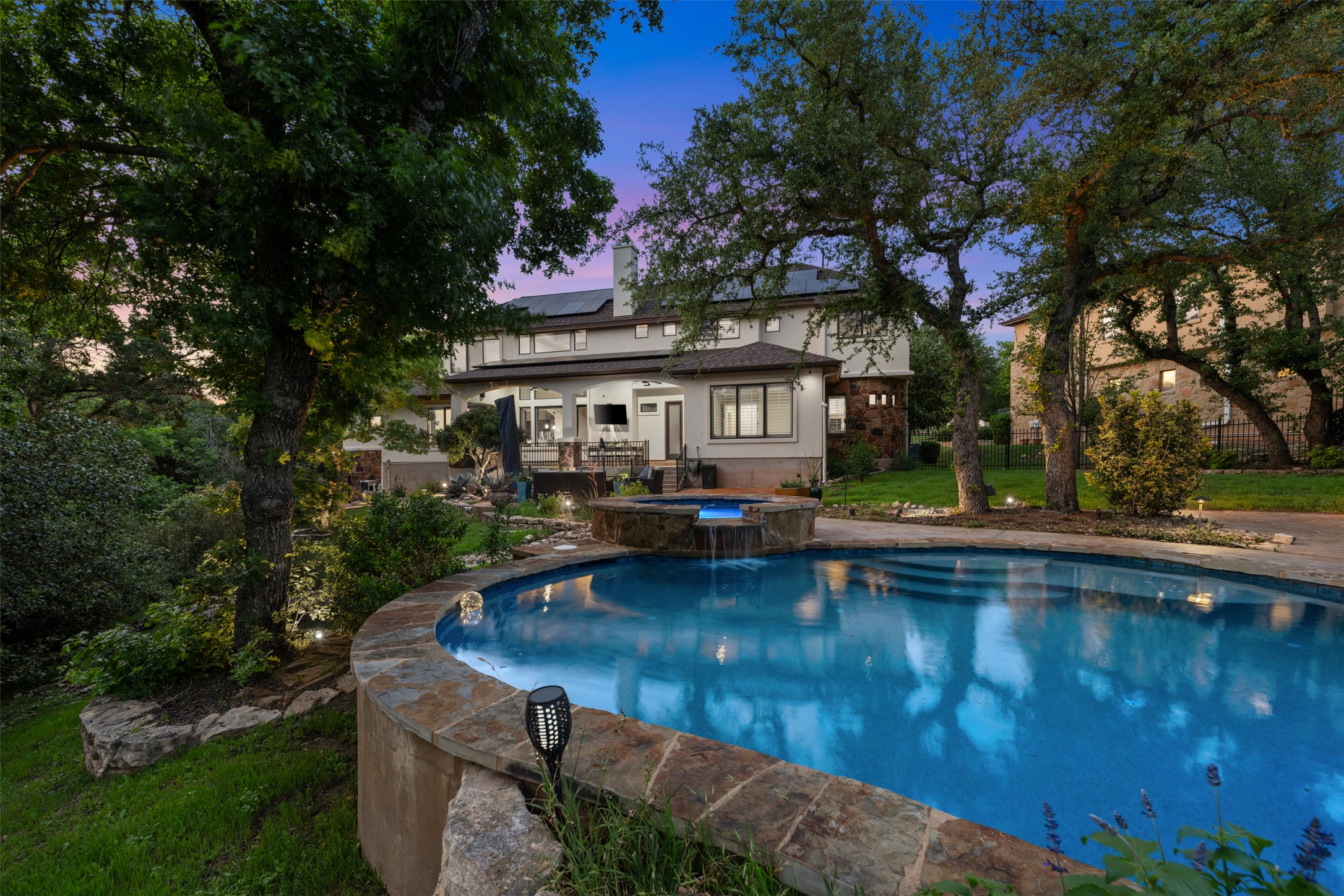 1102 Paw Print Leander, TX 78641 - Photo 39 of 40 The property features a large pool with stone coping, a raised spa with a waterfall, and a spacious patio area