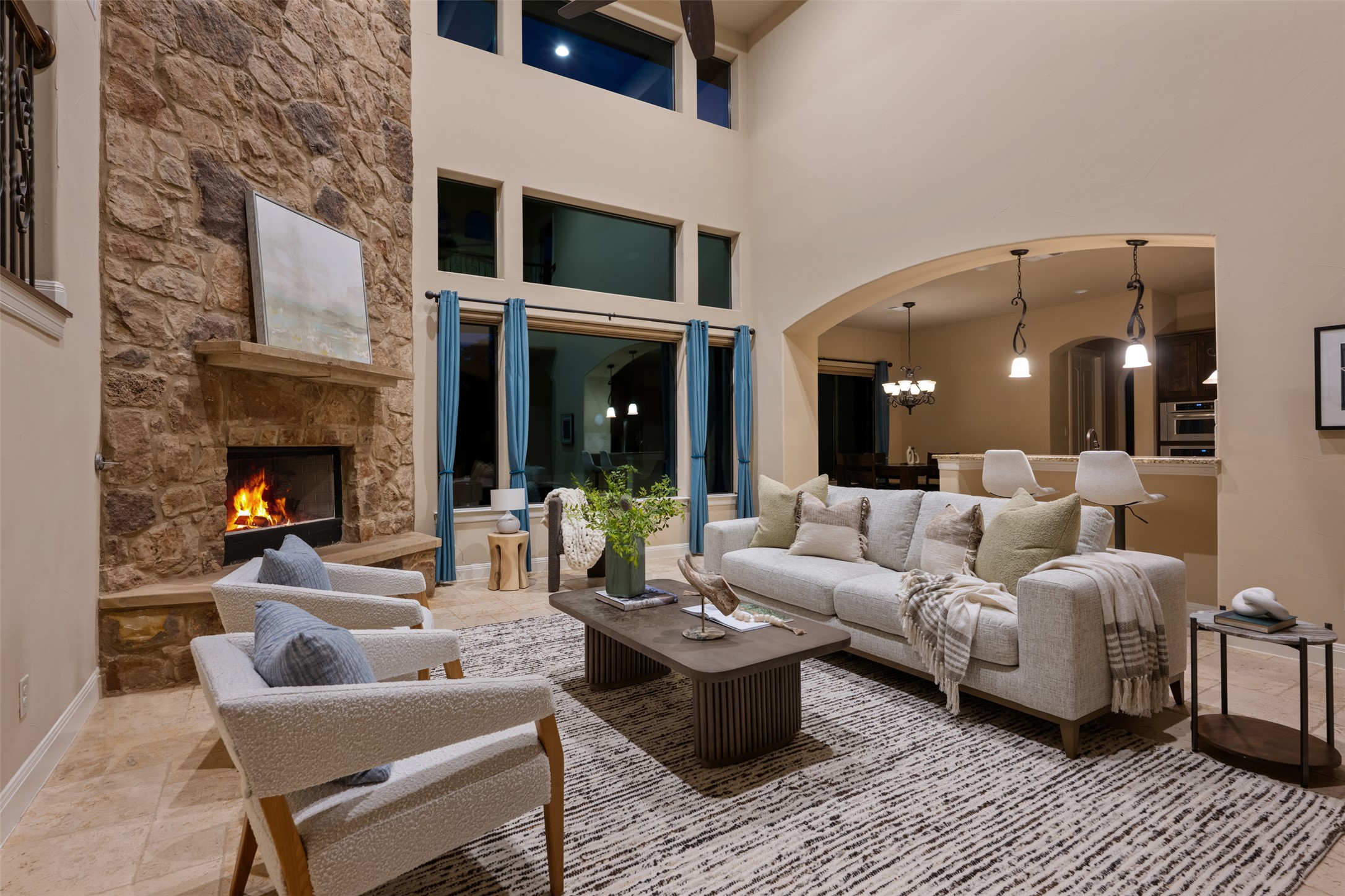 1102 Paw Print Leander, TX 78641 - Photo 40 of 40 The living room features high ceilings, a stone fireplace, and large windows with blue drapery