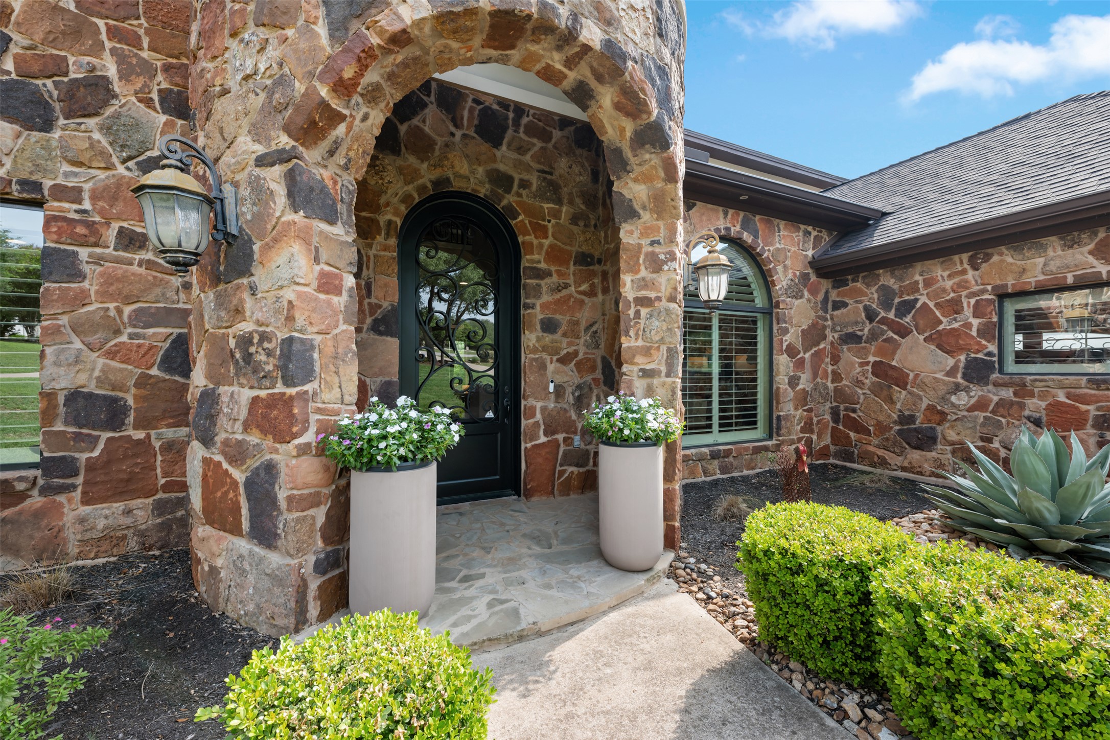 1102 Paw Print Leander, TX 78641 - Photo 4 of 40 The property features an archway entry with stone facade and a decorative front door