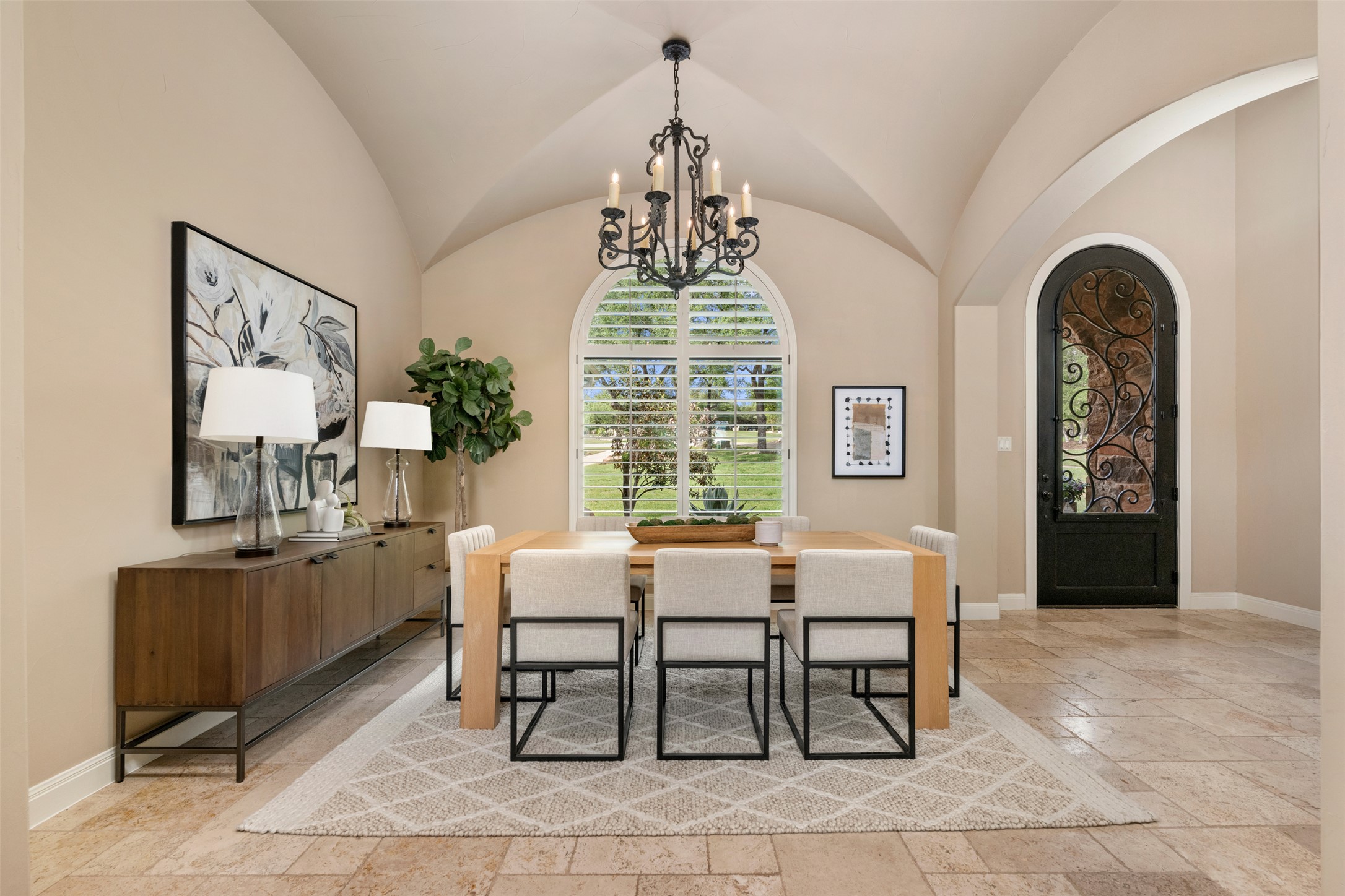1102 Paw Print Leander, TX 78641 - Photo 6 of 40 Dining area featuring a vaulted ceiling, an arched window with shutters, and a wrought iron chandelier