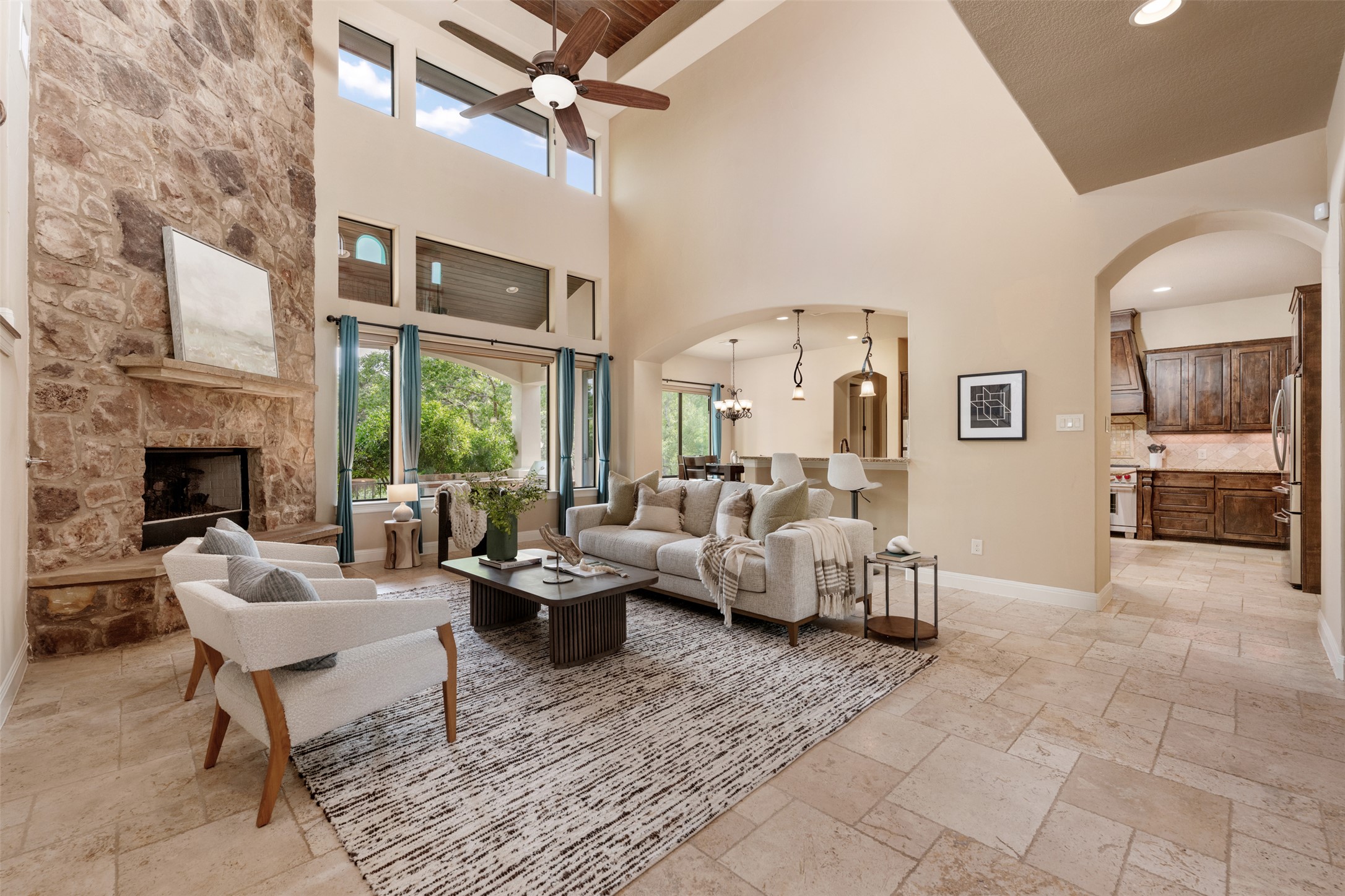 1102 Paw Print Leander, TX 78641 - Photo 8 of 40 The living room features high ceilings, a stone fireplace, and large windows providing abundant natural light
