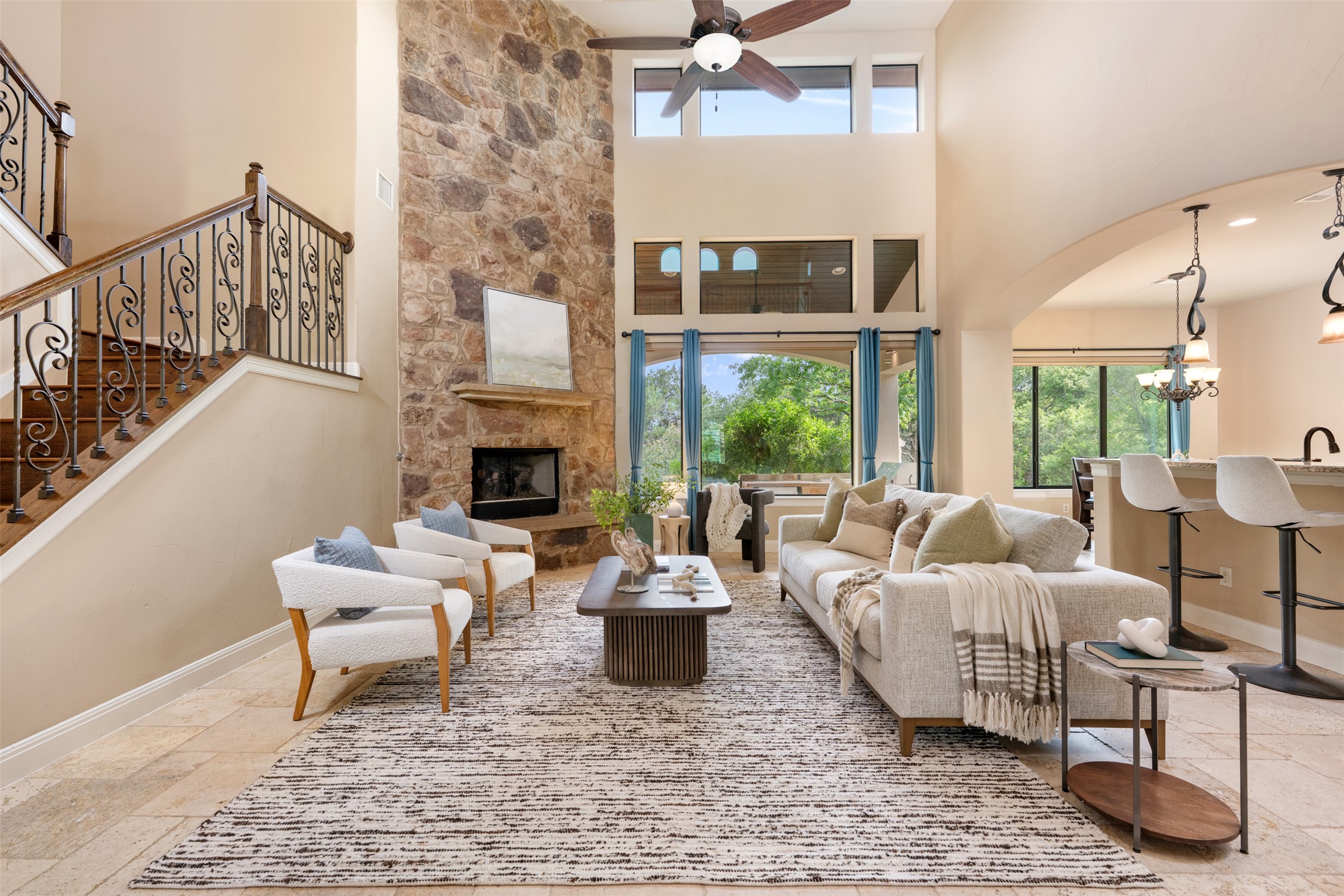 1102 Paw Print Leander, TX 78641 - Photo 9 of 40 This living space features high ceilings, a stone accent wall with a fireplace, and large windows providing ample natural light