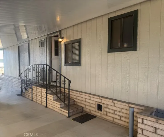 a view of a door and chair in front of house