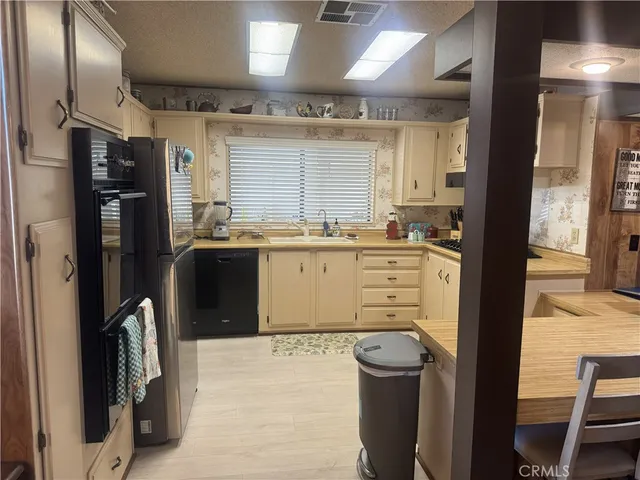 a kitchen with granite countertop a sink stove and cabinets