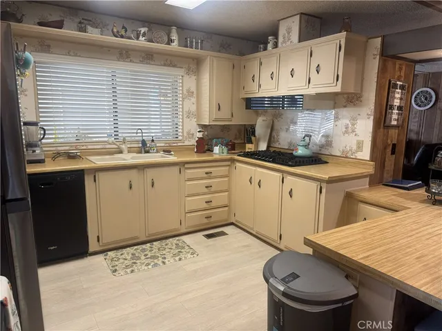 a kitchen with granite countertop a sink a stove and cabinets