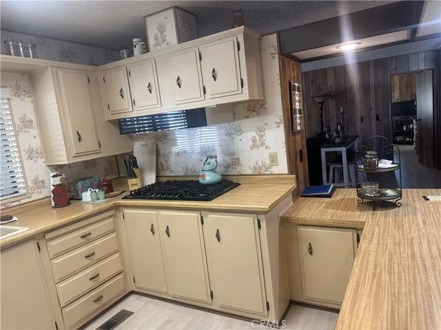 a kitchen with stainless steel appliances kitchen island granite countertop a refrigerator a sink a stove and white cabinets