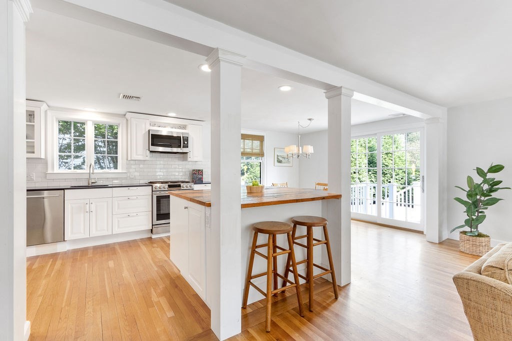 5 Mayflower Road Needham, MA 02492 - Photo 7 of 30 a kitchen with stainless steel appliances a refrigerator a stove a sink dishwasher and white cabinets with wooden floor