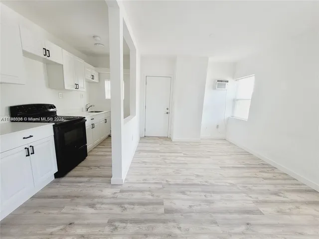 a kitchen with granite countertop a refrigerator and a stove top oven