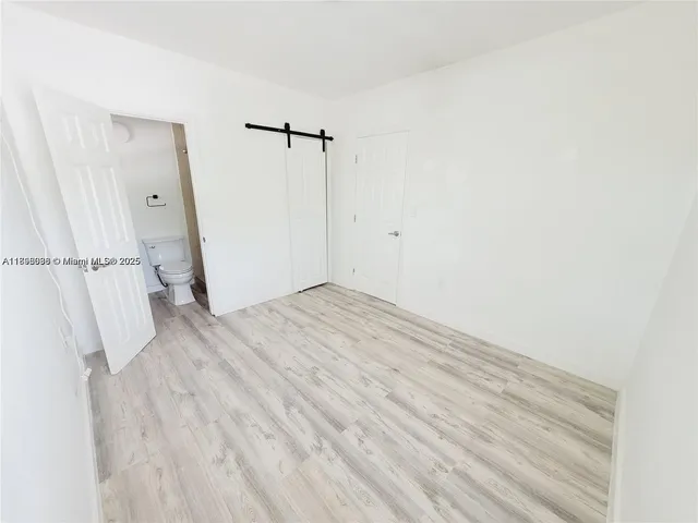 a view of empty room with wooden floor and window