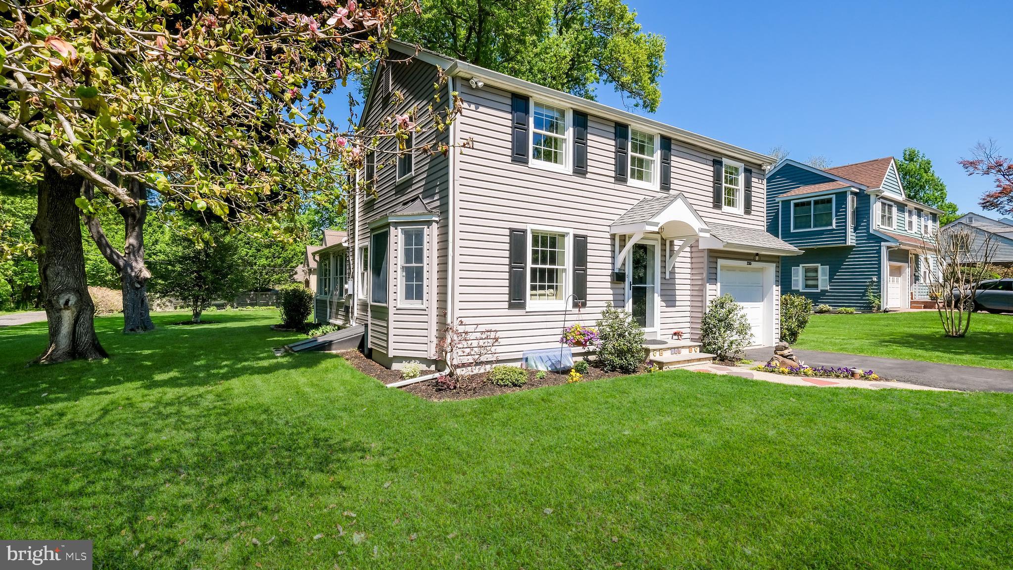 a front view of a house with a yard and trees