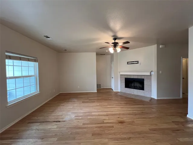 a view of an empty room with a fireplace and a window