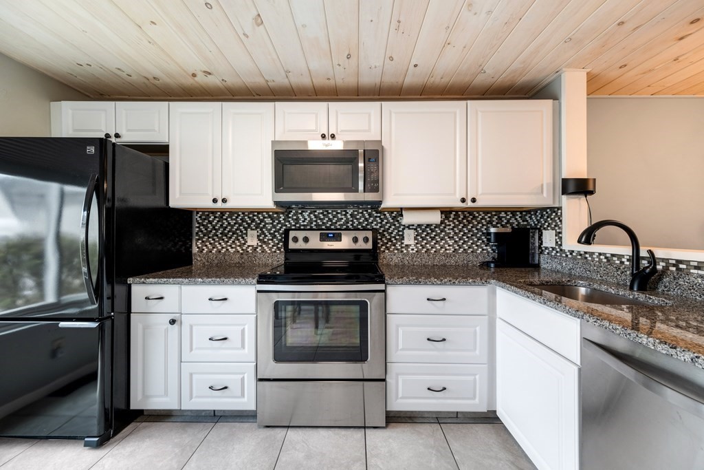 55 Stone Ridge Road, Unit 55 Franklin, MA 02038 - Photo 4 of 27 a kitchen with white cabinets and stainless steel appliances