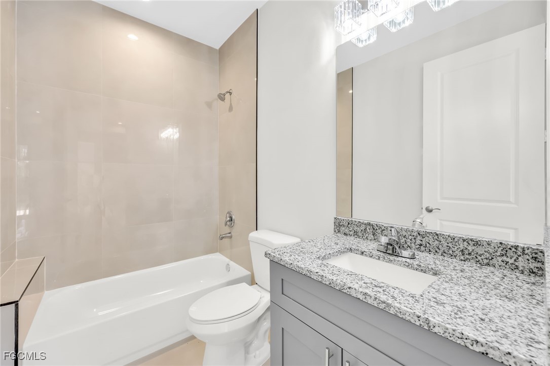 8771-8773 Buckingham Road Lehigh Acres, FL 33971 - Photo 14 of 34 a bathroom with a granite countertop sink a toilet and shower