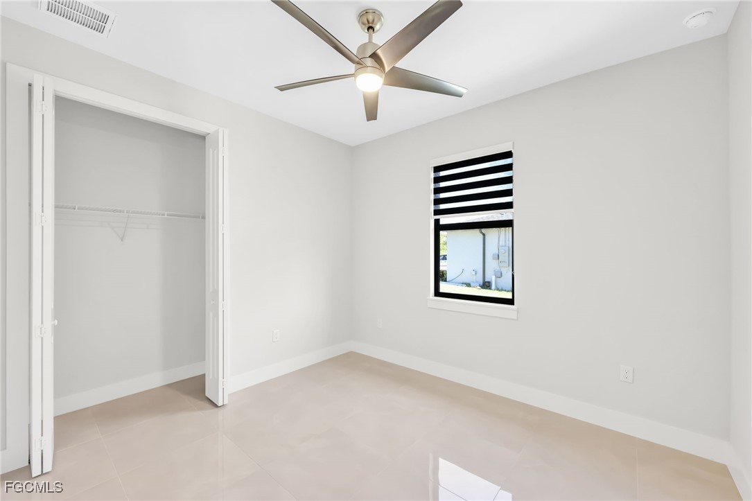 8771-8773 Buckingham Road Lehigh Acres, FL 33971 - Photo 16 of 34 an empty room with windows and ceiling fan
