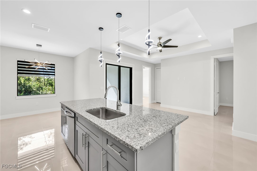 8771-8773 Buckingham Road Lehigh Acres, FL 33971 - Photo 20 of 34 a kitchen with kitchen island granite countertop a sink a counter top space and living room view